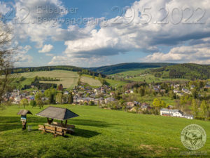 Nachdem in den letzten 2 Jahren gar keine, bzw. nur eine kleine Version des Wanderklassikers im Oberland organisiert werden durfte, ist es nun endlich an der Zeit, wieder das volle Programm für alle Wanderfreunde zu reaktivieren.  Der Bergwanderverein Erlbach lädt am Sonntag, den 29. Mai 2022 alle Wanderbegeisterten aus nah und fern zur 42. Auflage der traditionsreichsten Wanderung im Vogtland ein. Start ist wie immer zwischen 7:00 Uhr und 09:30 Uhr im Museumshof des Freilichtmuseums in Eubabrunn.  Um allen Wanderfreunden das geeignete bieten zu können, wurden insgesamt 5 Varianten erarbeitet. Für die kleinsten gibt es auf der 5km Familientour an Stationen viel in der Natur zu entdecken. Die 8km geführte Wanderung bringt neben der tollen Aussicht vom Hohen Stein auch jede Menge Informationen mit sich.  Gemütlich, aber schon im zweistelligen Kilometerbereich führt die 13km Trasse eine kleine Schleife um die Aussichtspunkte von Erlbach. Die trainierteren oder sportlichen Läufer können über einen Elstergebirgswegabschnitt in die Berghöhen um das Schwarzbachquellgebiet in der Landesgemeinde aufsteigen. Hier sind 20km bzw. 27km zur Auswahl. An den Strecken werden Helfer an verschiedenen Kontrollpunkten mit Fettbroten und Tee die Teilnehmer wieder stärken.  Wichtig hierbei ist zu beachten, dass um Plastemüll zu vermeiden, die bereit gehaltenen Getränke nur in eigene Becher oder Tassen abgefüllt werden. Hierzu bieten sich natürlich alle Arten von Mehrwegbecher an. Viele werden bestimmt ein solches Souvenir noch von der letzten Bergwanderung besitzen und dabeihaben. Wer noch ohne unterwegs ist, kann natürlich auch am Start oder an den Kontrollstellen einen Becher käuflich erwerben.  Ab der Mittagszeit werden dann die ankommenden Wanderer auf den letzten Schritten von Blasmusik der originalen Erlbacher Schwarzbachmusikanten empfangen. Für den Hunger und Durst gibt es natürlich frisches Faßbier, Limo, Kuchen und Roster.  Eine vorherige Anmeldung zur Wanderung ist nicht nötig, da alle Formalitäten am Start kurz vor dem Loslaufen erledigt werden können.  Wir vom Bergwanderverein hoffen sie recht herzlich bei uns begrüßen zu dürfen.